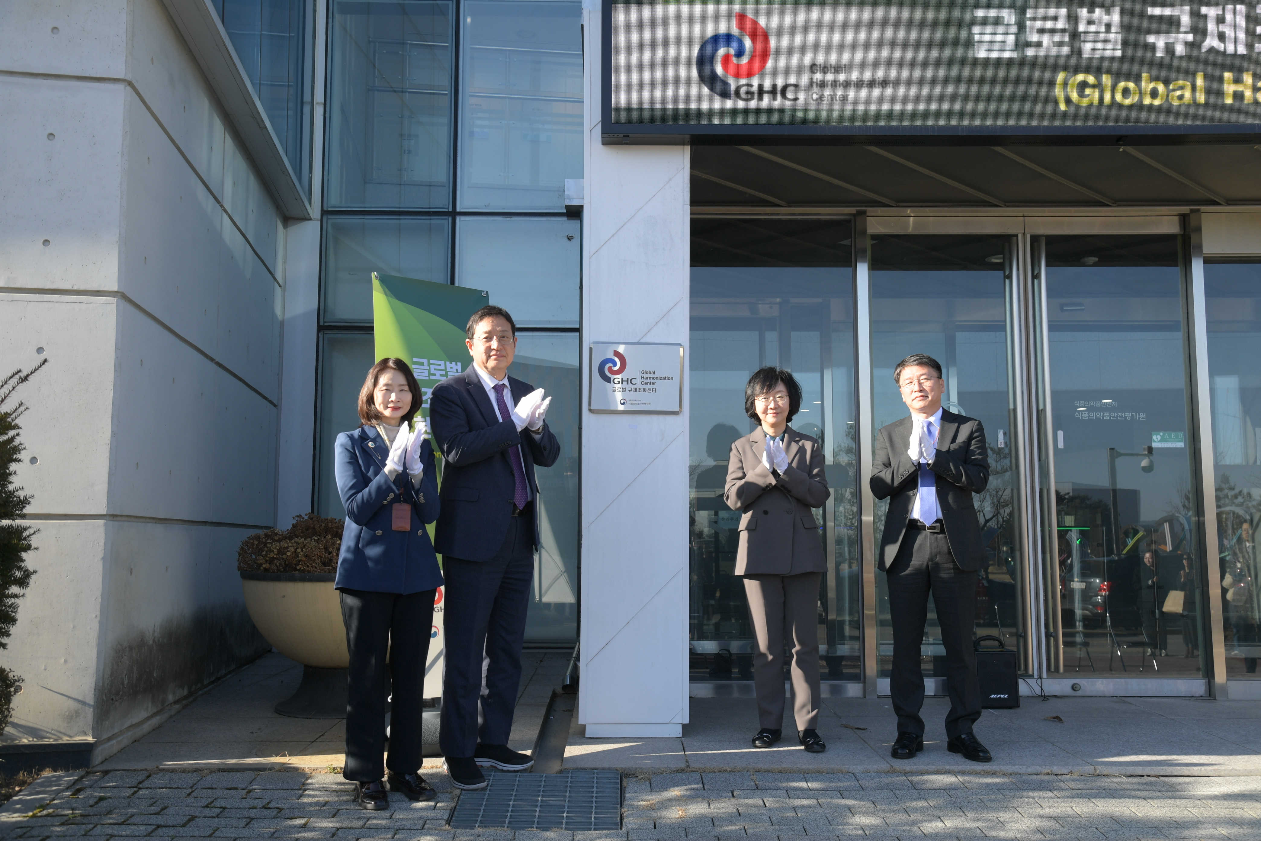 Standing by the center's plaque